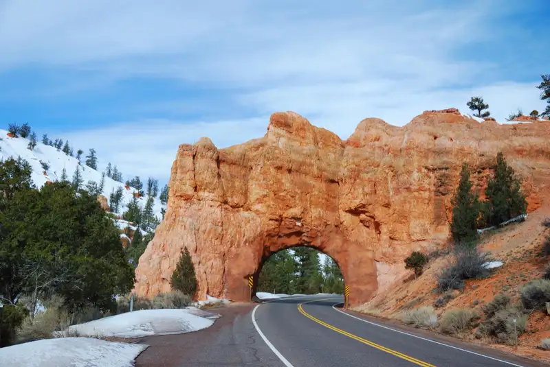 Road going through an arch in Red Canyon